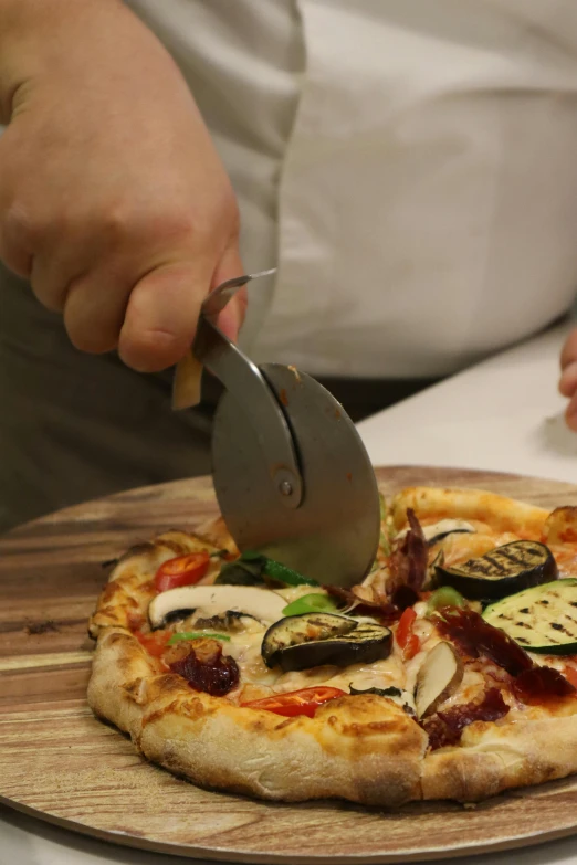 a person  a pizza on top of a wood plate