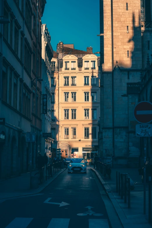 the cars are going down the road past buildings