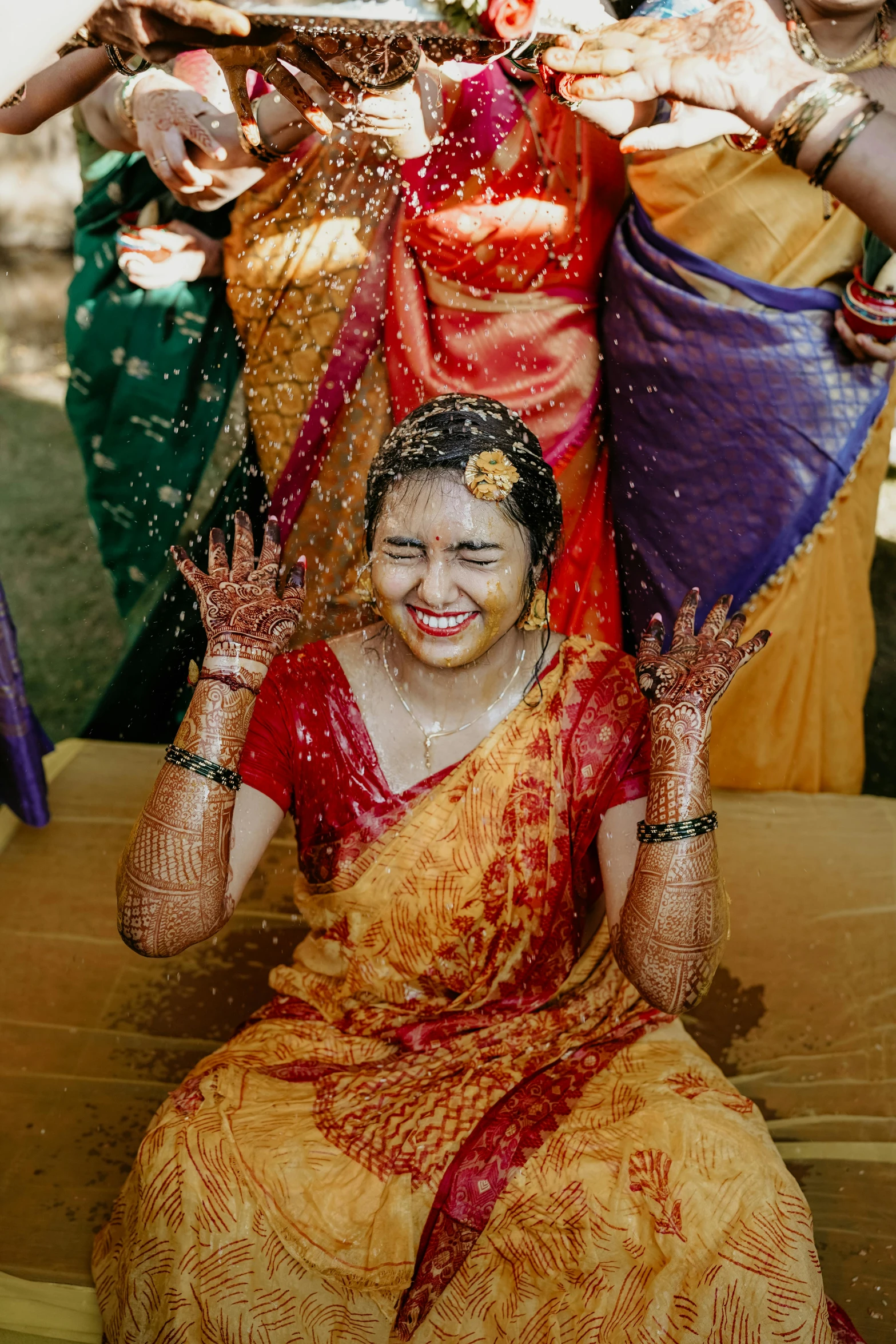 a woman with painted hands getting soaked by her friends