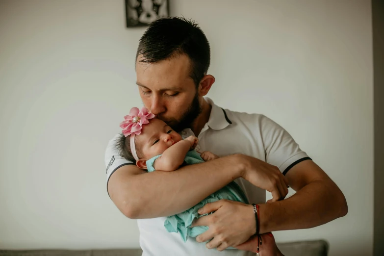 man holding baby in hands during session