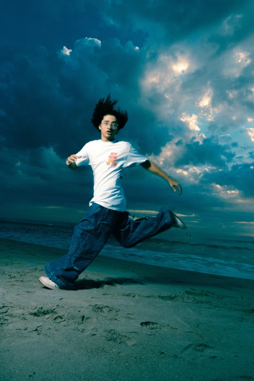 man running along beach during cloudy sunset on sunny day