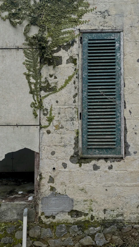 an old window and a grate on the side of a building