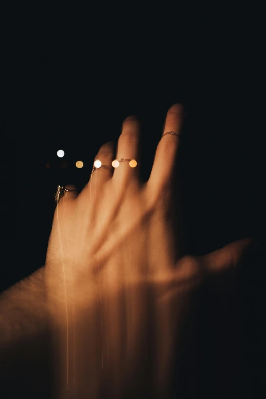 a woman's hands held up at night