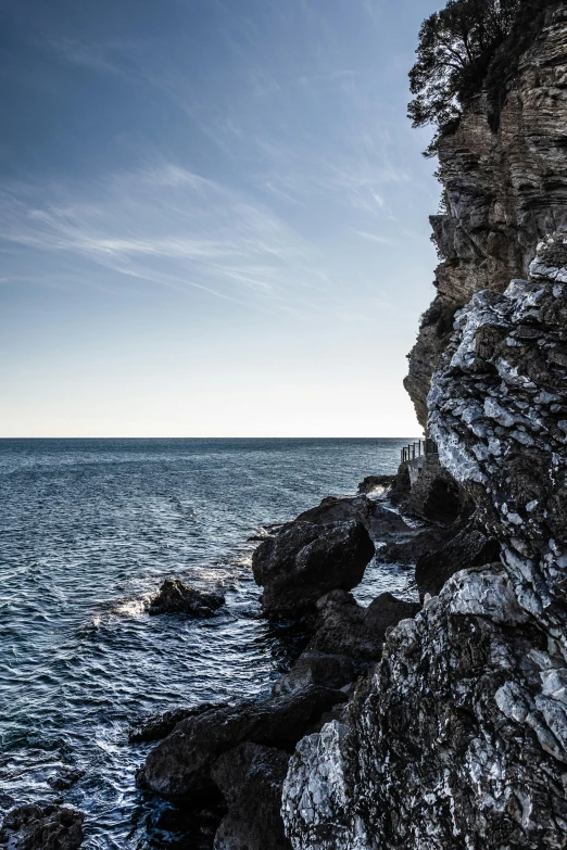 the person is standing on the cliff by the water