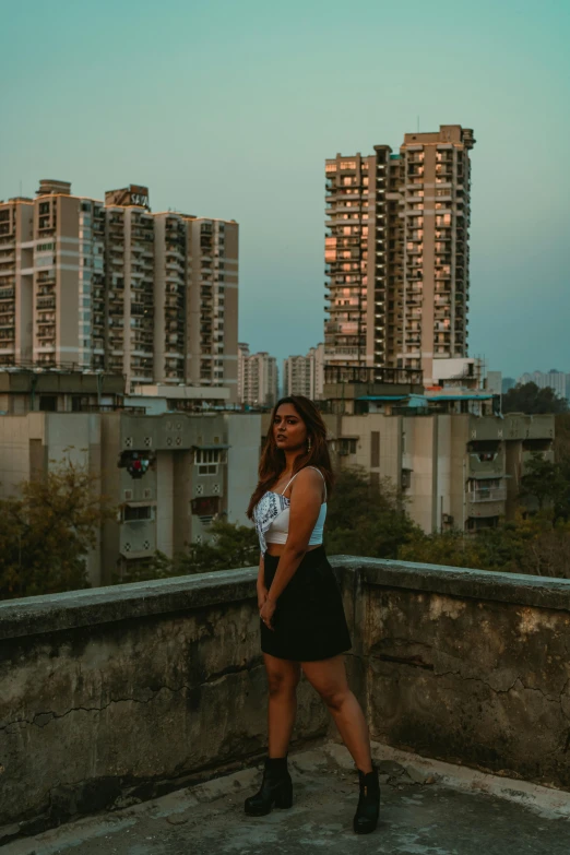 woman wearing black skirt and white top at the edge of the rooftop