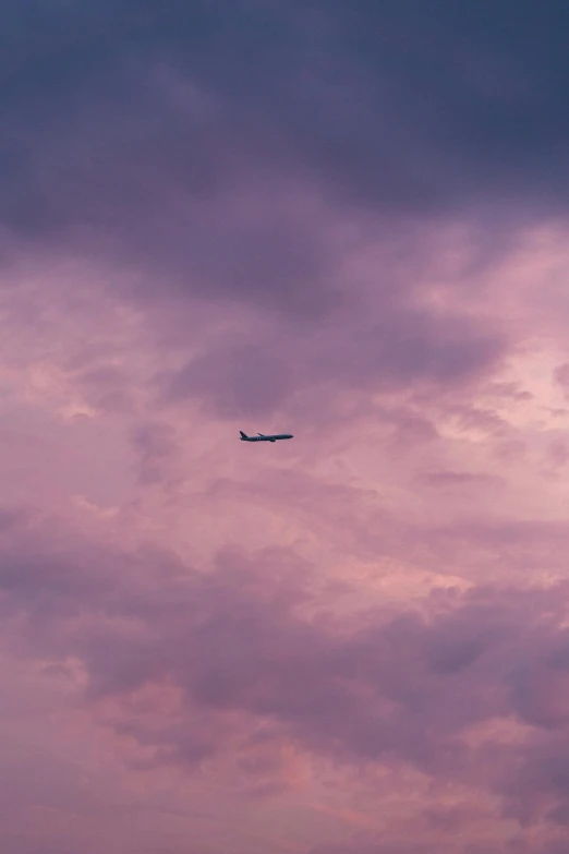 an airplane flying through the sky with clouds in the background