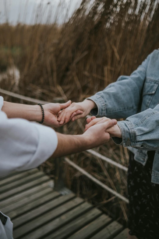 two people hold hands and touch each other