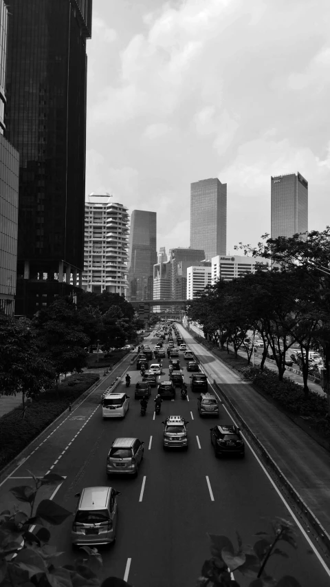 the cars are driving down the road towards city buildings