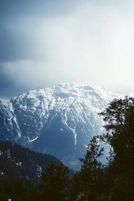 a mountain covered in snow under a gray sky