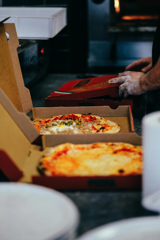 some slices of pizza in boxes and on the counter