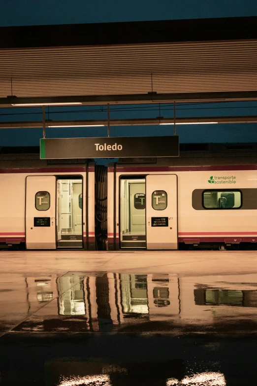 two train cars parked at a platform in front of a station