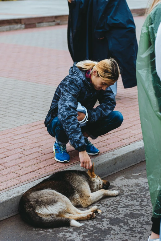 a woman wearing blue boots petting a husky dog