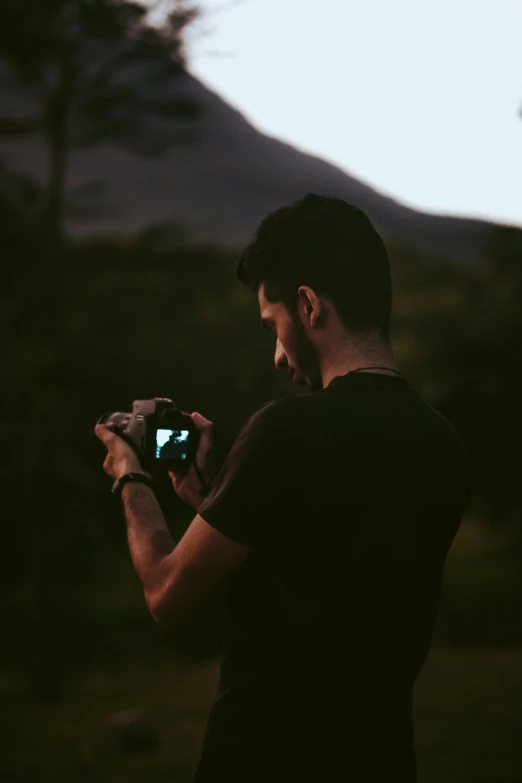 a man standing with a camera taking a po