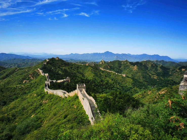 the great wall in china surrounded by hills and greenery