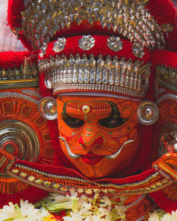 a carnival performer with flowers surrounding it and mask