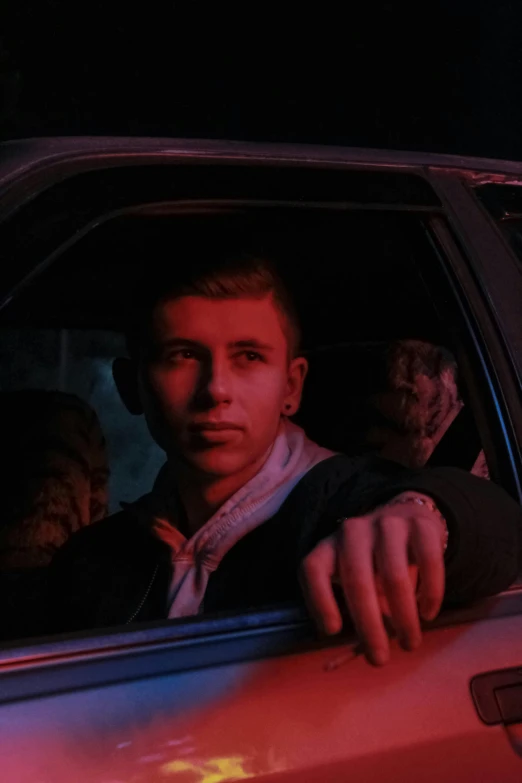 a man driving a car while holding the door open