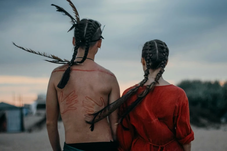 two people with long ids and a native american body paint