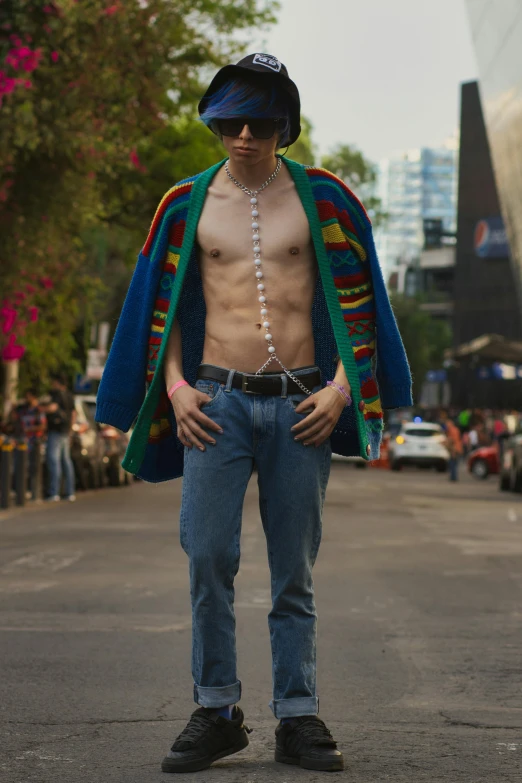 man with beads wearing hat, shirtless body and blue jean jeans