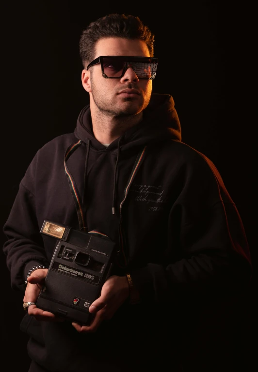 a man in glasses holding a small radio