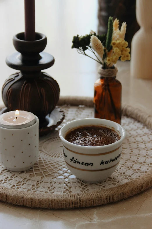 a table with a tray holding a bowl of food and two candles