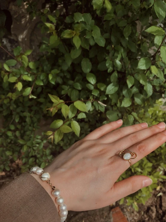 a person's hand and her left hand with two rings on it