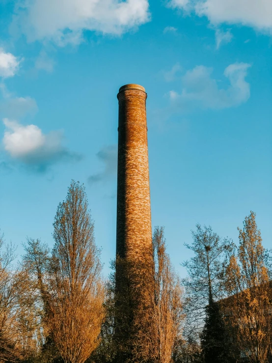 a brick tower standing in front of some trees