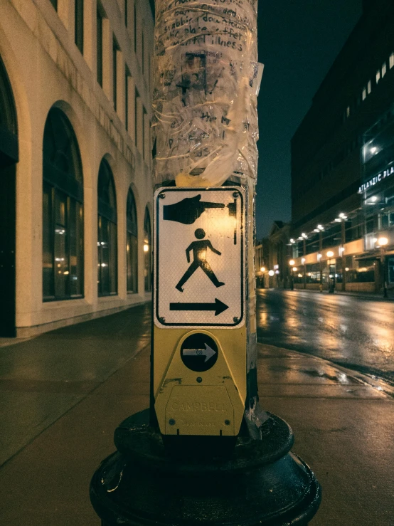 a traffic sign standing on a street side next to a tree