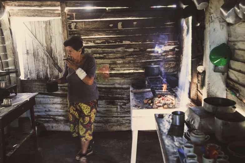 an older woman cooking in a rustic kitchen