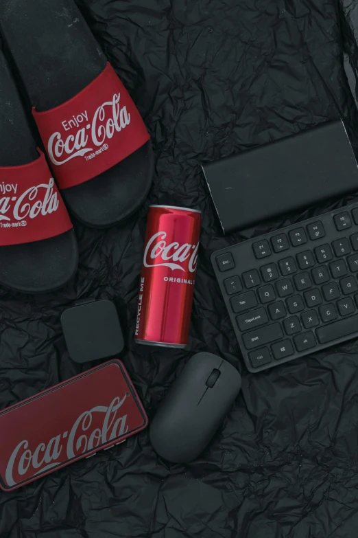 keyboard, mouse, coke can and computer accessories laid out on a bed