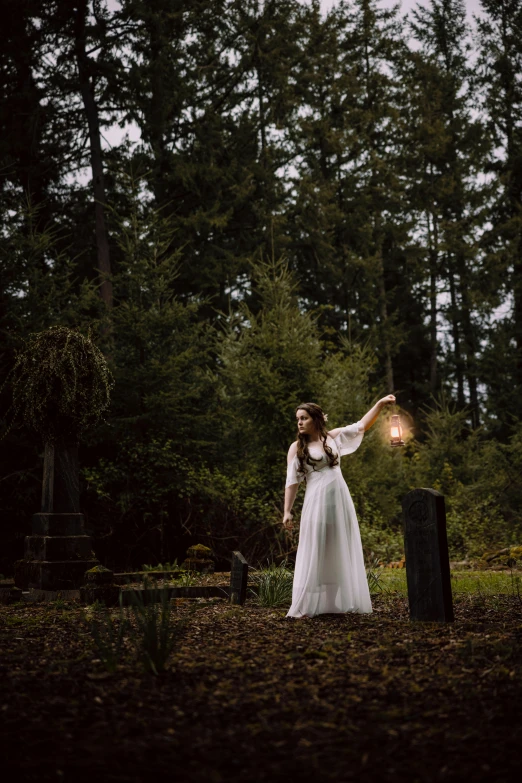 woman in wedding dress with light glowing in the woods