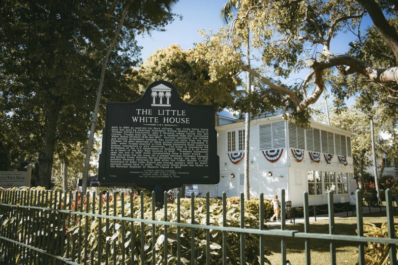 a historic white picket fence is shown next to a sign