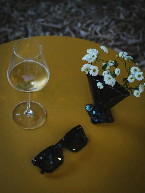 two glasses and some flowers are setting on a table