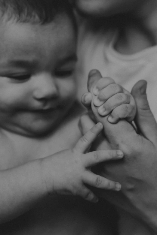 an adult holding a baby in his arms