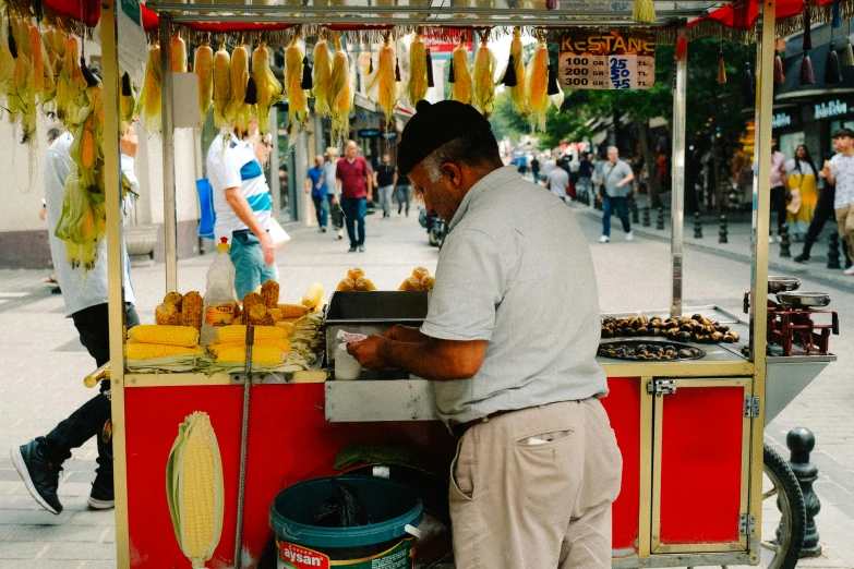 man with white shirt standing near food stand