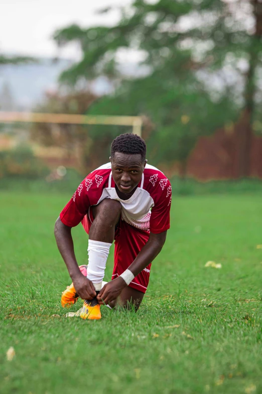 a soccer player kneeling on the ground with a ball