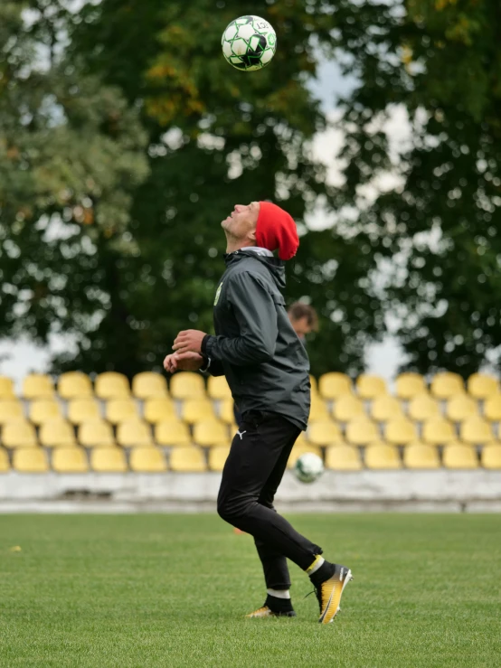 a man standing on top of a field with a soccer ball