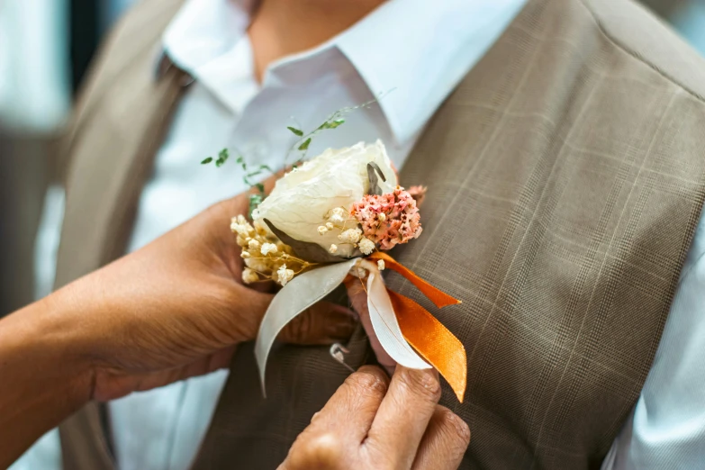 a close up of a person tying a flower