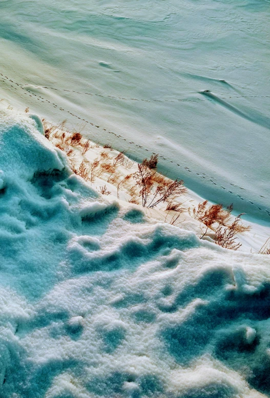 snow covers some ground and grass in the background