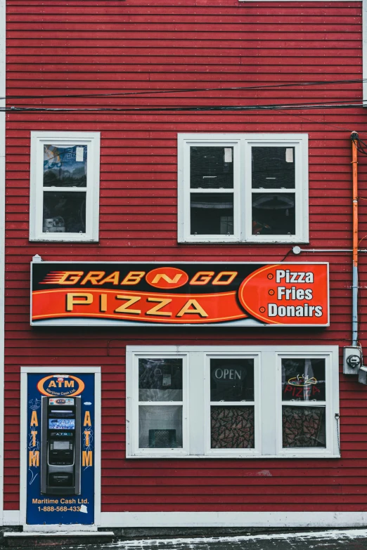 a po of a pizza place with a red building in the background