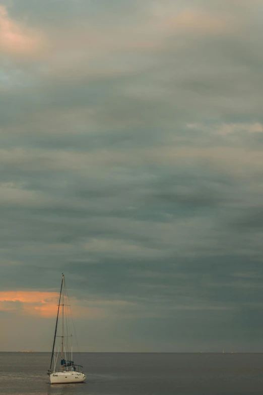 a white sail boat traveling across an ocean