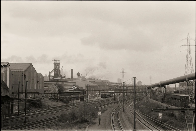 vintage looking industrial setting with railcars and steam stacks