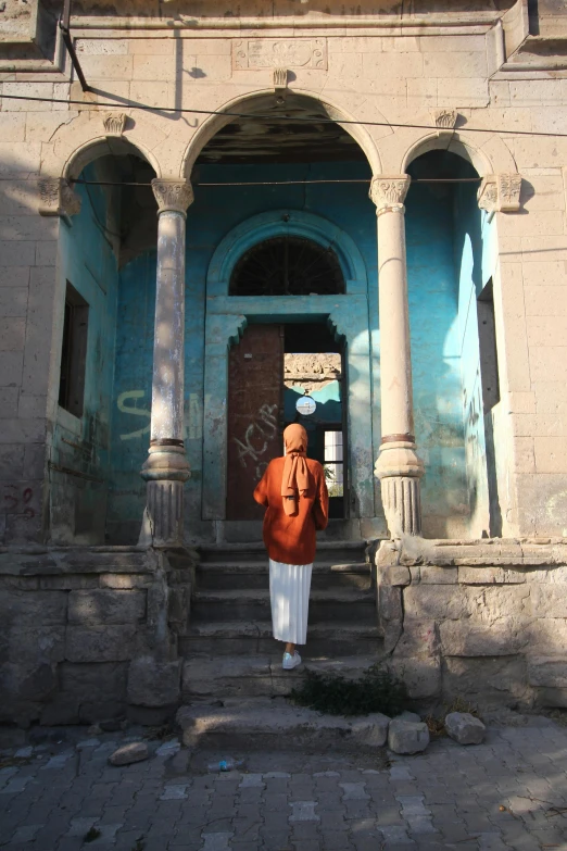 a woman is standing outside an old building