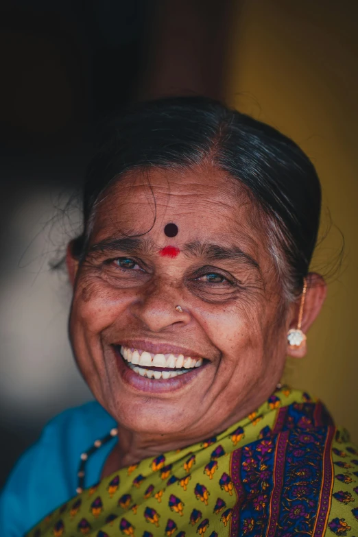 smiling woman with piercings on her face and green blouse