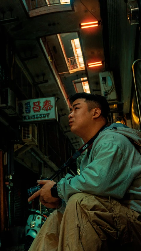 an oriental man is sitting on the side walk
