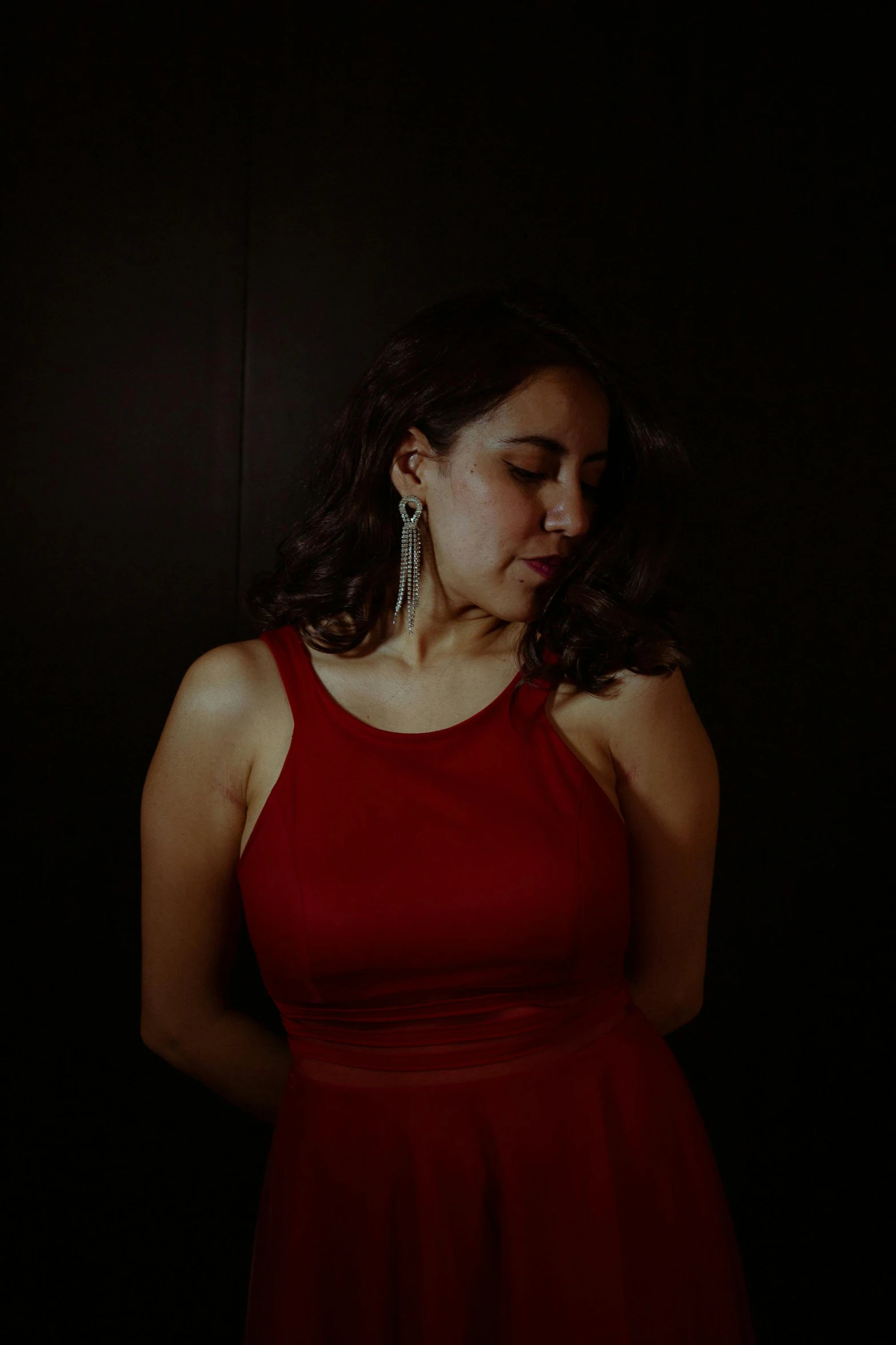 a girl is in red dress and is looking down