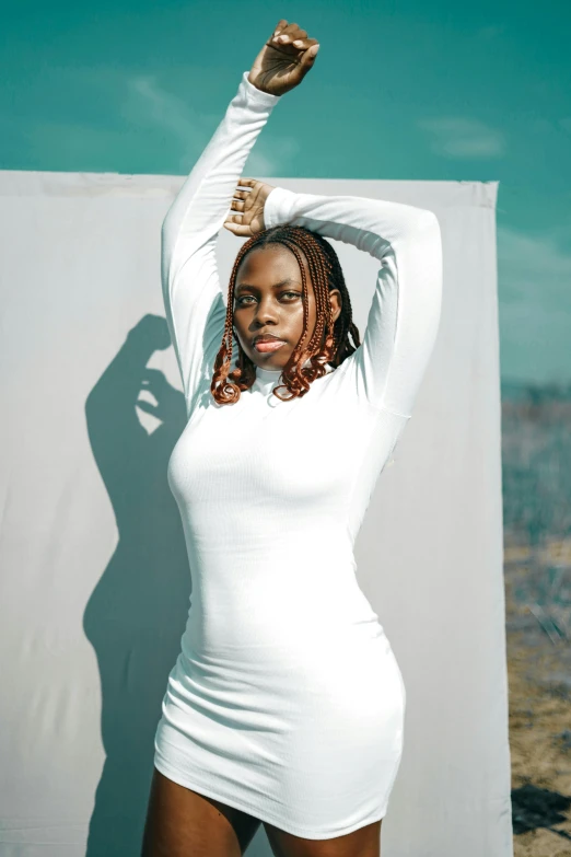 a woman in a white bodysuit posing and holding up her hands