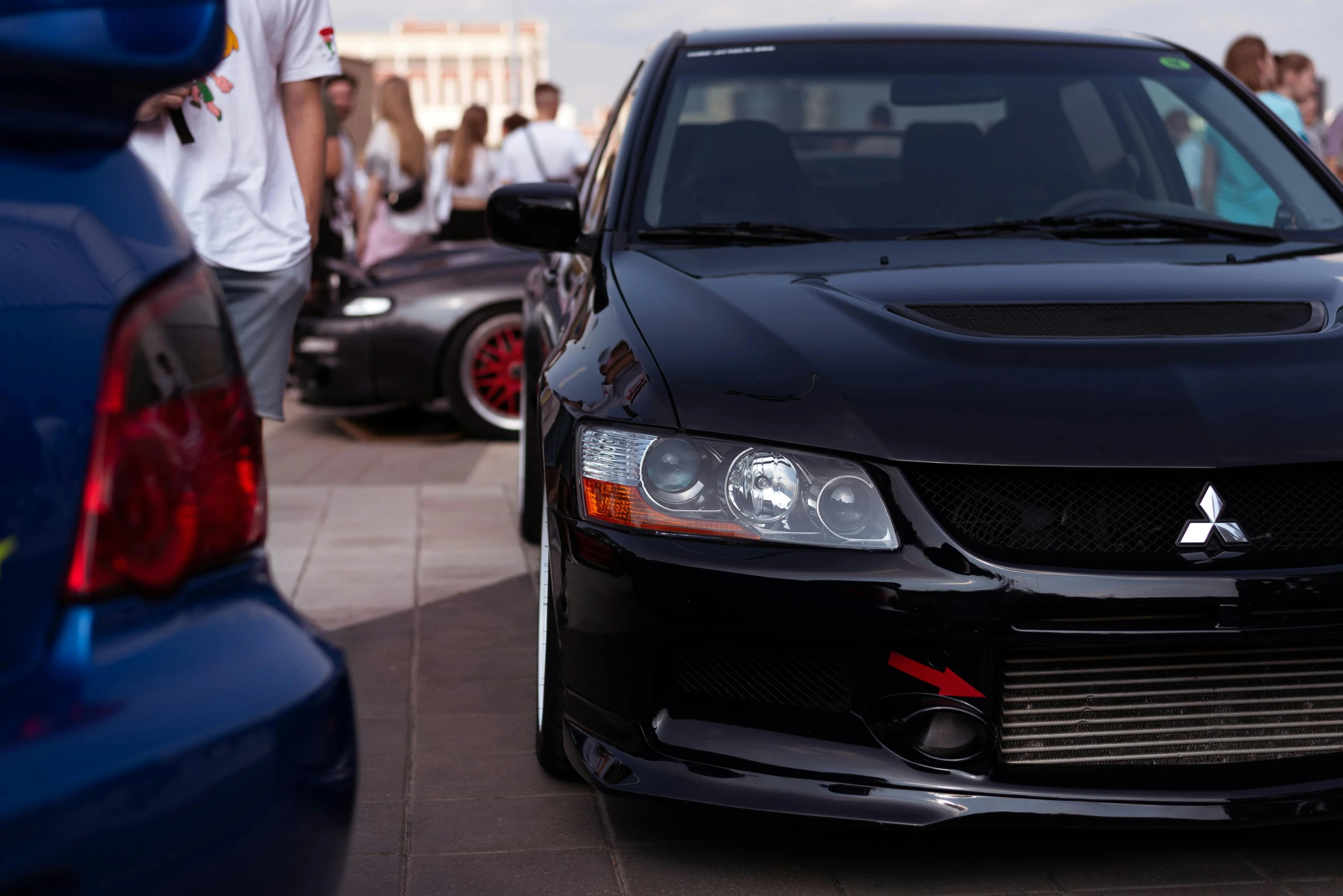 a black car parked in front of some other cars