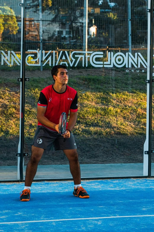 a man is holding a tennis racket on a tennis court