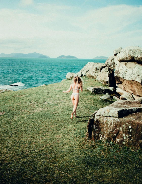 a woman in a bikini running away from the water