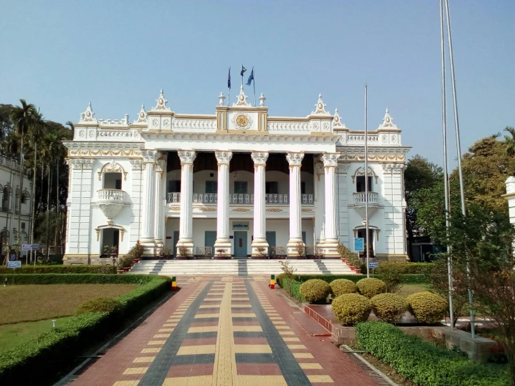 a tall building sitting in front of a lush green park